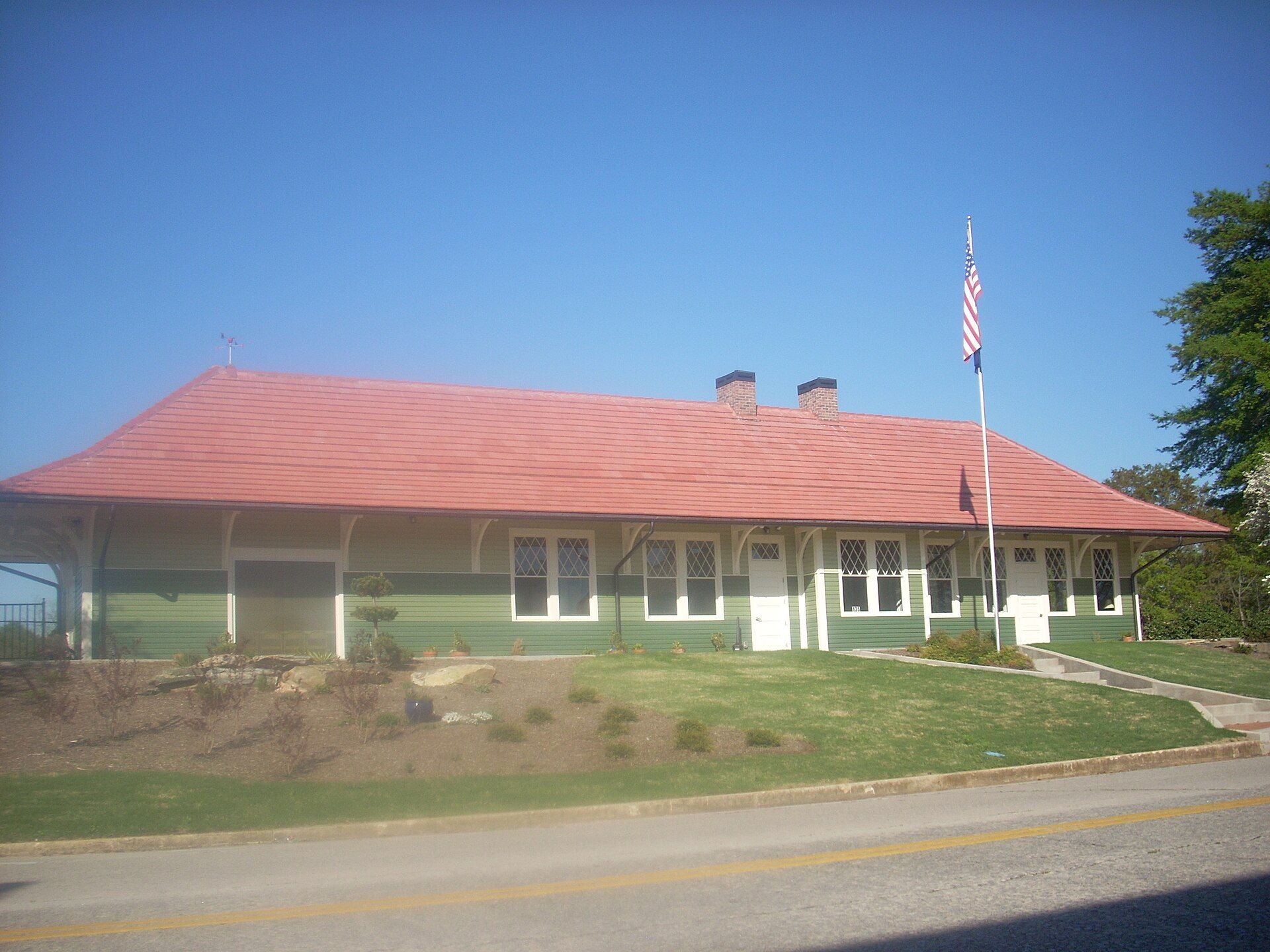 Westminster's restored railroad depot, a long green clapboard building with a red tile roof, two brick chimneys and a flagpole.
